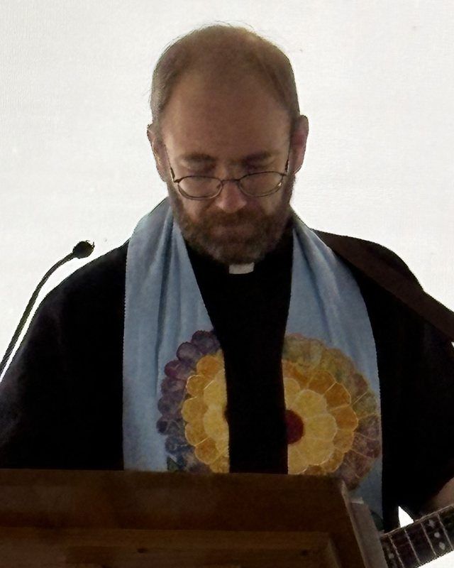 Pastor Will Layton in a stole at the lectern