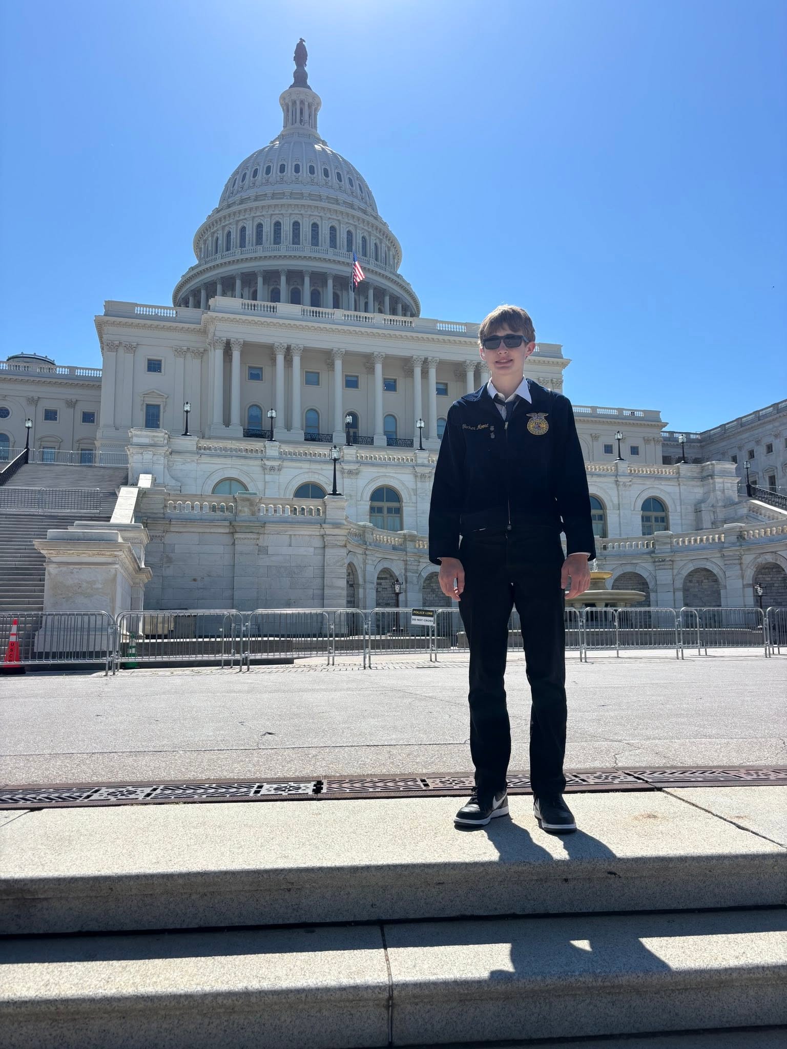 A member in an FFA jacket stands in front of the U.S. Capitol.