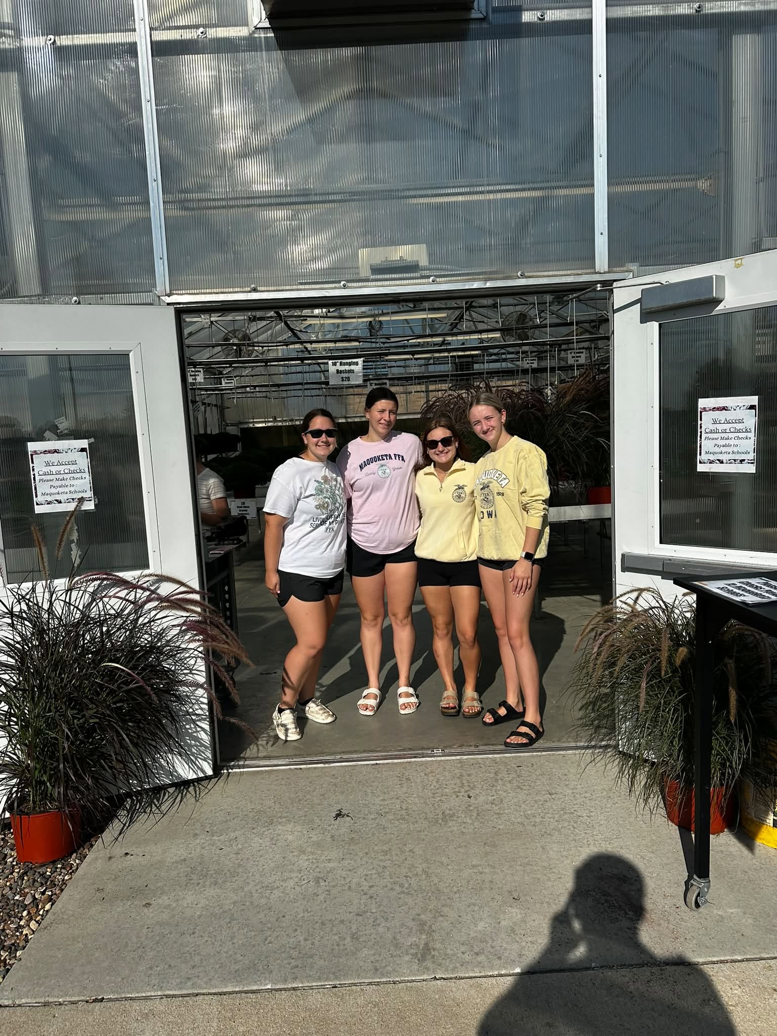 Four members standing in the doorway of the greenhouse.