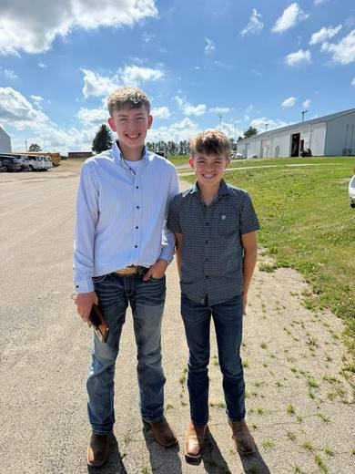 Two young members stand side by side outdoors.