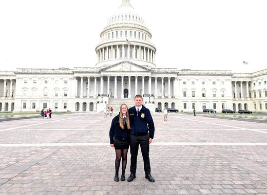 Two members stand in the plaza in front of the U.S. Capitol.